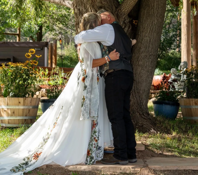 Bride and groom embracing under a willow tree at Three Willows Ranch rustic wedding venue in Colorado
