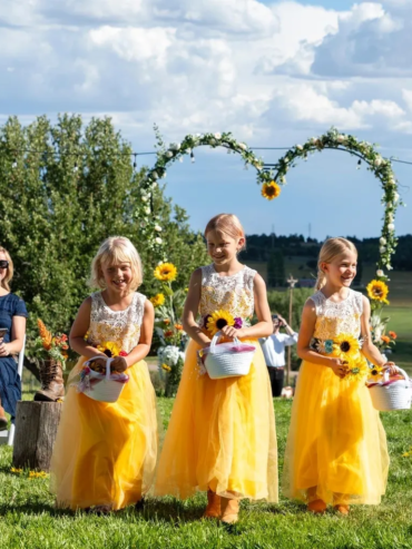 Flower girls walking down the aisle during an outdoor wedding ceremony at Three Willows Ranch Colorado