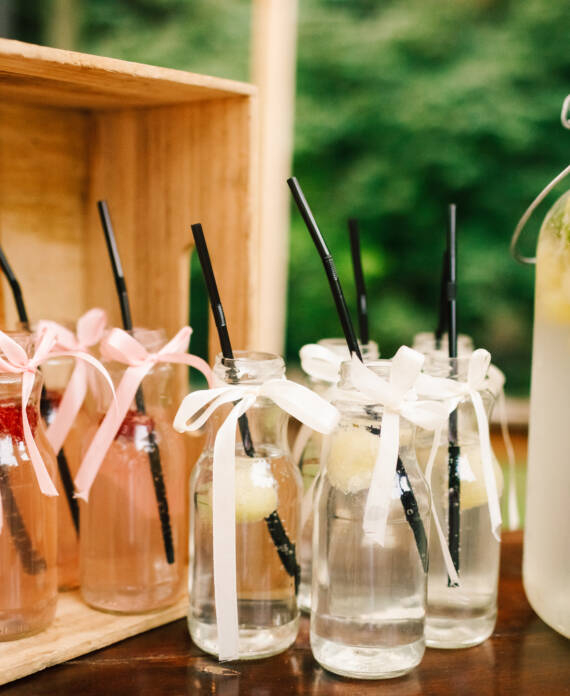 Bottle with fresh lemonade and glasses around it stands on the d