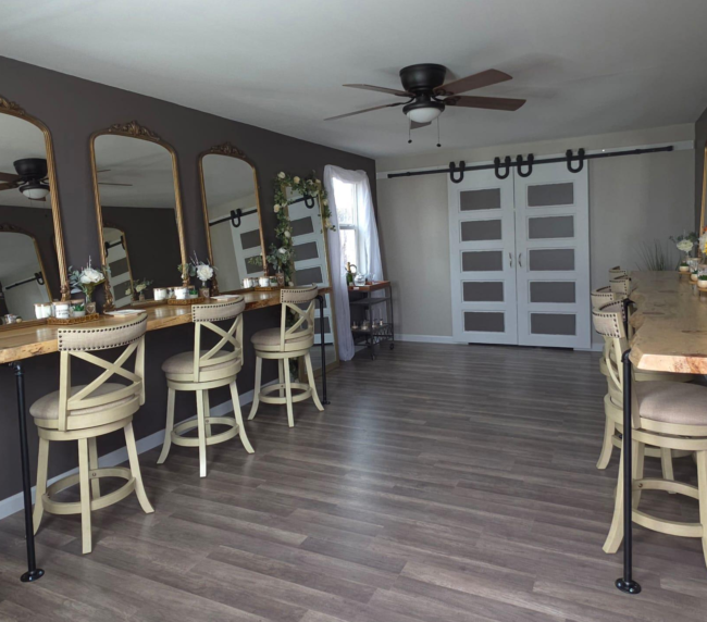 Spacious bridal suite at Three Willows Ranch featuring vanity mirrors, wooden styling counters, barstools, and rustic modern décor.