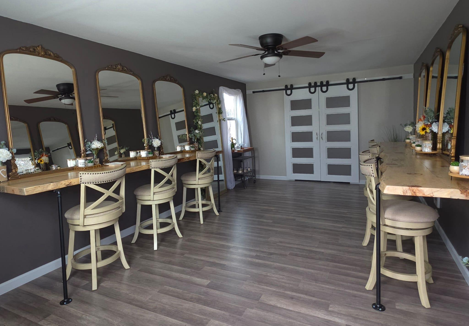 Spacious bridal suite at Three Willows Ranch featuring vanity mirrors, wooden styling counters, barstools, and rustic modern décor.