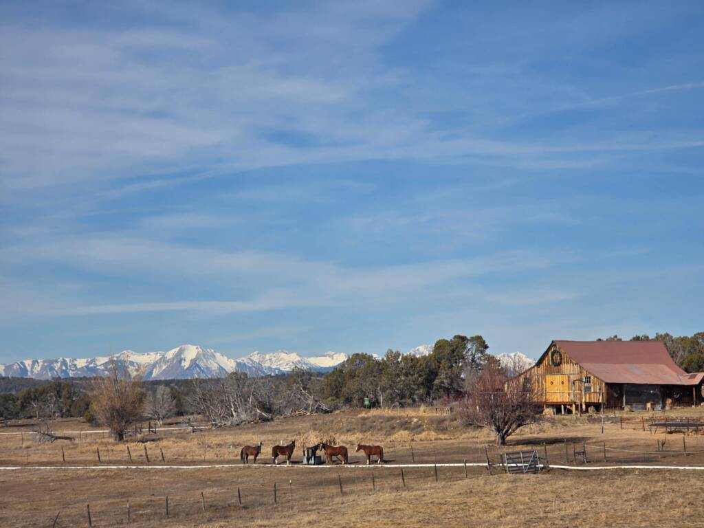 Rustic barn wedding venue near Bayfield Colorado with mountain backdrop and open ranch landscape