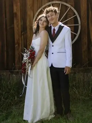 Bride and groom posing in front of a rustic barn wall at Three Willows Ranch wedding venue in Colorado