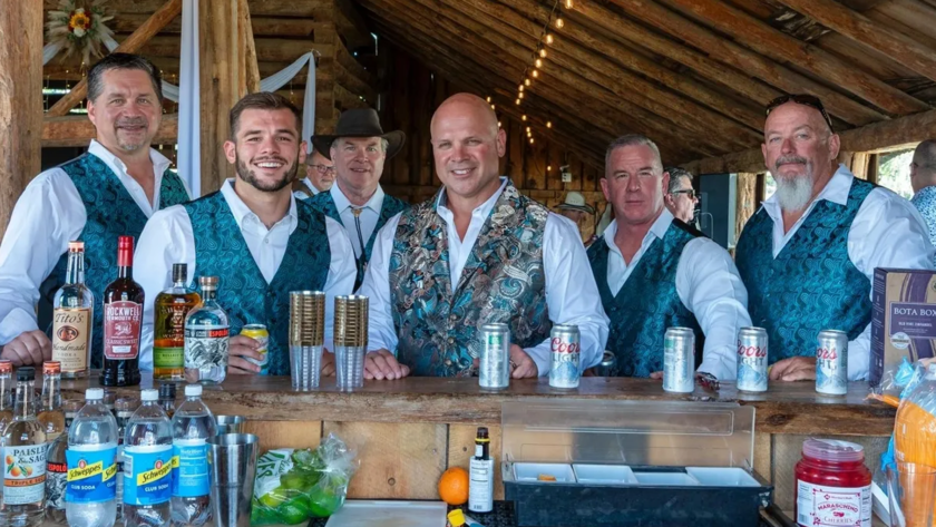 Bartenders serving drinks at the rustic barn bar area during an event at Three Willows Ranch Colorado
