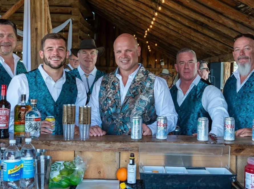 Bartenders serving drinks at the rustic barn bar area during an event at Three Willows Ranch Colorado