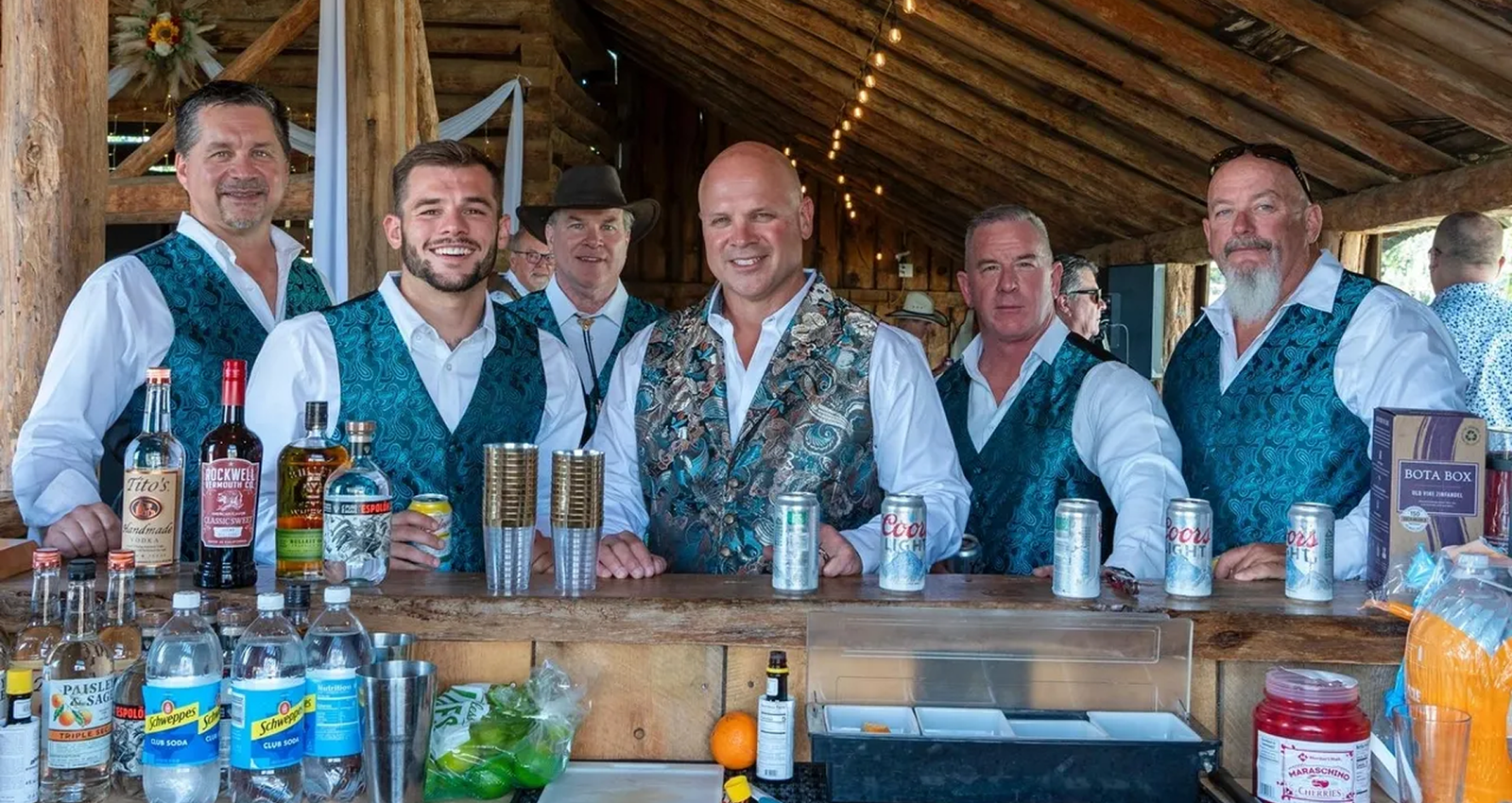 Bartenders serving drinks at the rustic barn bar area during an event at Three Willows Ranch Colorado