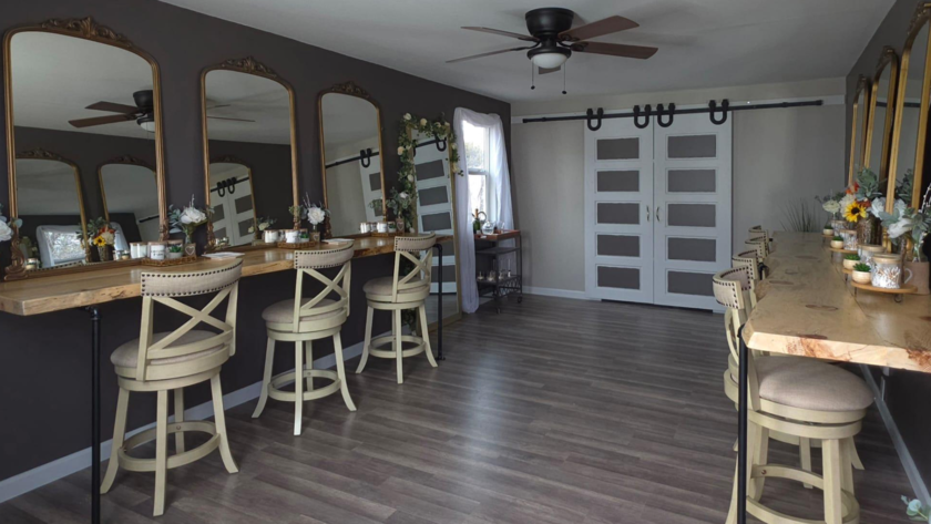 Spacious bridal suite at Three Willows Ranch featuring vanity mirrors, wooden styling counters, barstools, and rustic modern décor.