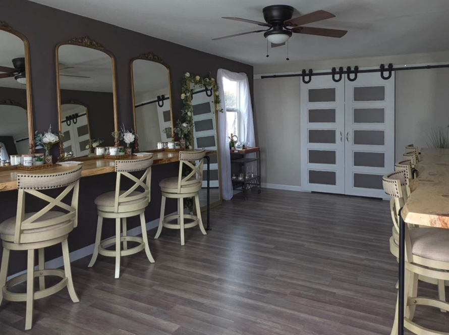 Spacious bridal suite at Three Willows Ranch featuring vanity mirrors, wooden styling counters, barstools, and rustic modern décor.