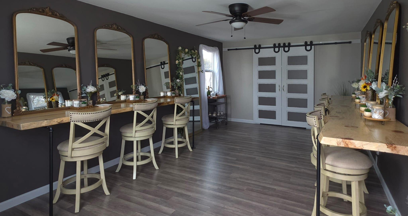 Spacious bridal suite at Three Willows Ranch featuring vanity mirrors, wooden styling counters, barstools, and rustic modern décor.