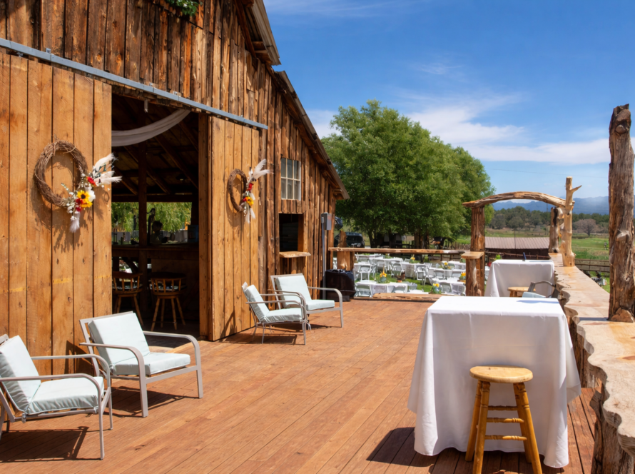 Rustic wooden barn deck at a Colorado ranch with outdoor seating, cocktail tables, and scenic countryside views for private gatherings
