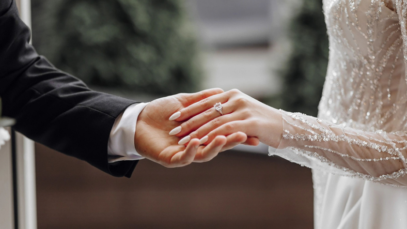 Close-up of a couple holding hands with an engagement ring at a rustic ranch setting in Bayfield Colorado, capturing a romantic engagement moment.