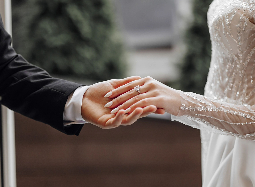 Close-up of a couple holding hands with an engagement ring at a rustic ranch setting in Bayfield Colorado, capturing a romantic engagement moment.