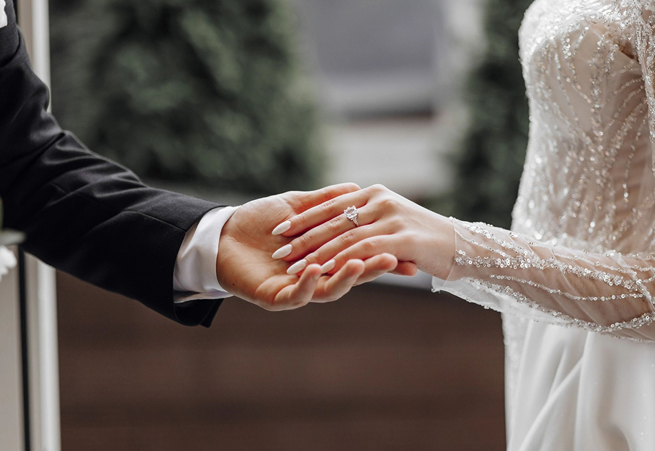 Close-up of a couple holding hands with an engagement ring at a rustic ranch setting in Bayfield Colorado, capturing a romantic engagement moment.