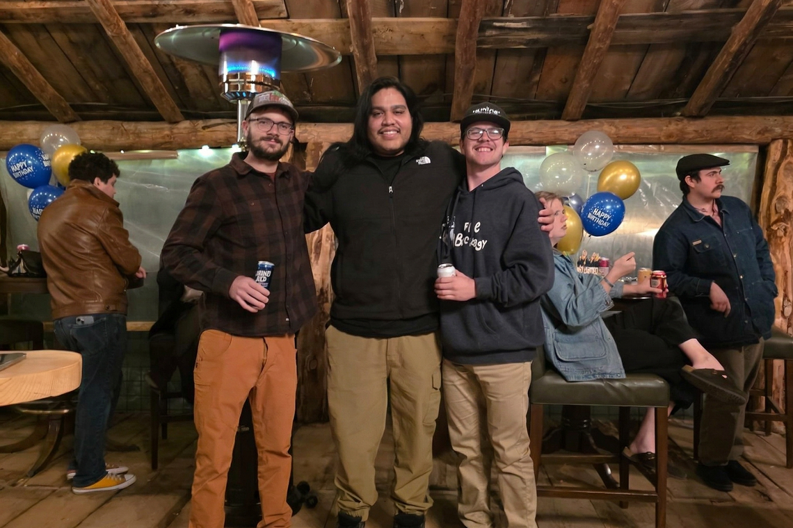 Friends posing together at a graduation party inside a rustic barn venue in Bayfield Colorado, enjoying a warm and festive atmosphere.