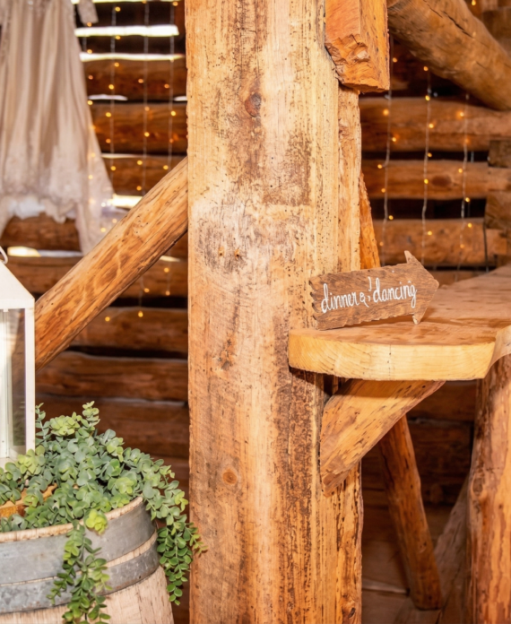 Rustic wedding decor with lantern, greenery, and wooden details inside the historic barn at Three Willows Ranch.