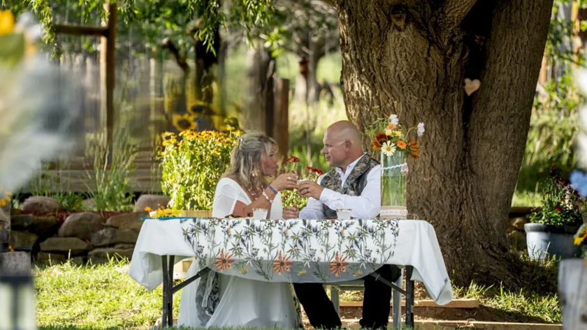 Couple enjoying a romantic outdoor dinner under a tree at Three Willows Ranch rustic wedding venue Colorado