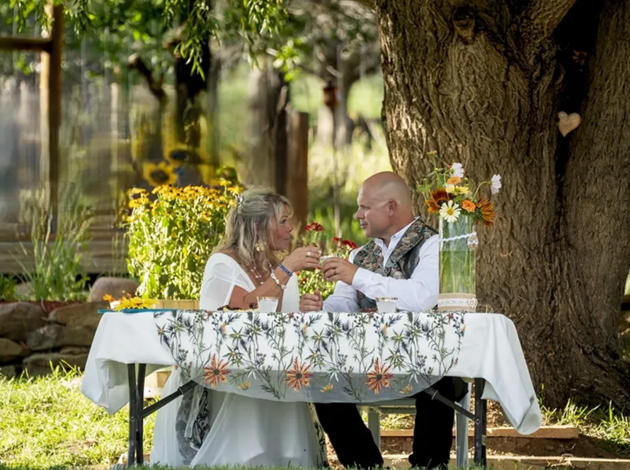 Couple enjoying a romantic outdoor dinner under a tree at Three Willows Ranch rustic wedding venue Colorado