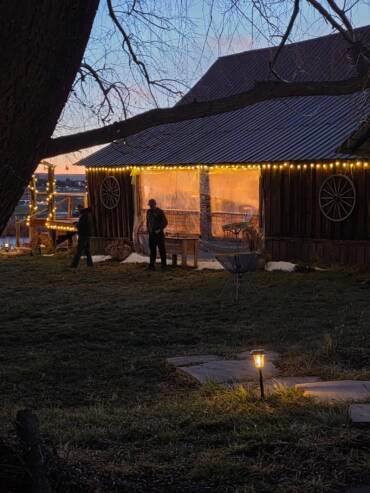 Rustic barn at Three Willows Ranch illuminated with warm lights during an evening event