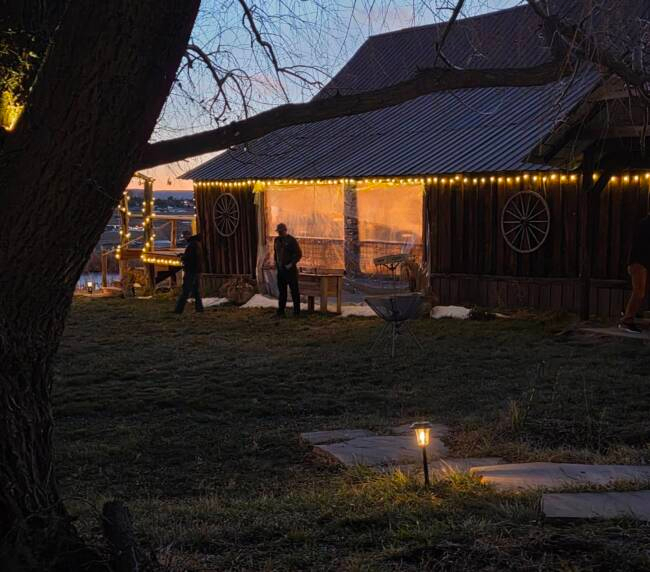 Rustic barn at Three Willows Ranch illuminated with warm lights during an evening event