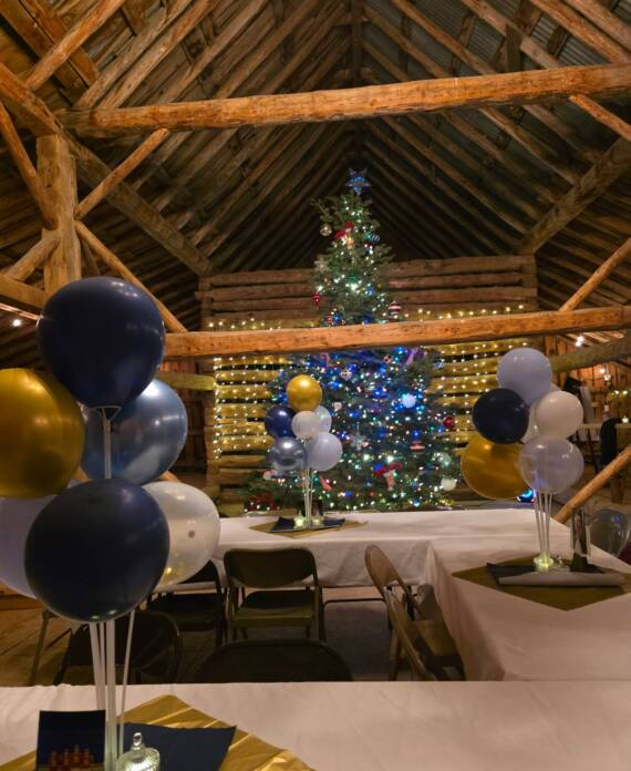 Decorated barn interior at Three Willows Ranch with tables, balloons, and festive lighting