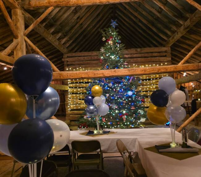Decorated barn interior at Three Willows Ranch with tables, balloons, and festive lighting