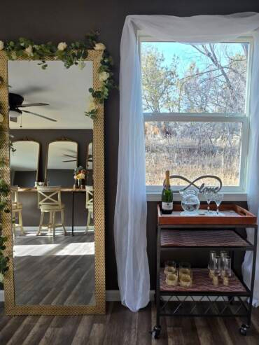 Bridal suite preparation area at Three Willows Ranch with mirror, vanity seating, and window decor