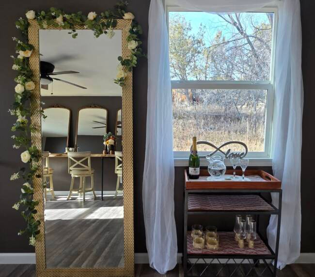 Bridal suite preparation area at Three Willows Ranch with mirror, vanity seating, and window decor