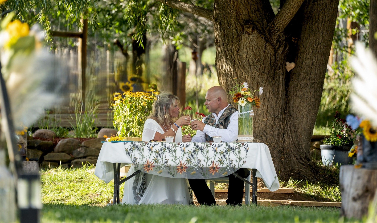 Couple enjoying a romantic outdoor dinner under a tree at Three Willows Ranch rustic wedding venue Colorado