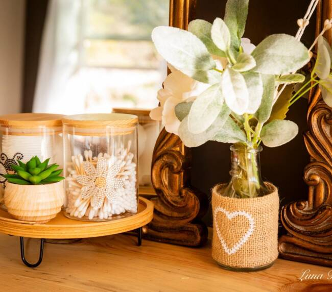 Close-up of bridal suite decor with floral arrangement, cotton pads, and rustic mirror