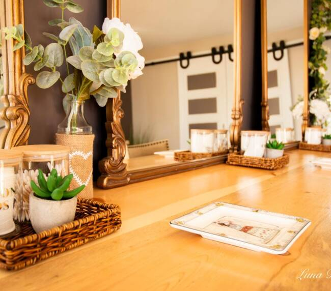 Bridal suite vanity with mirrors, floral decor, and beauty essentials in rustic barn wedding venue
