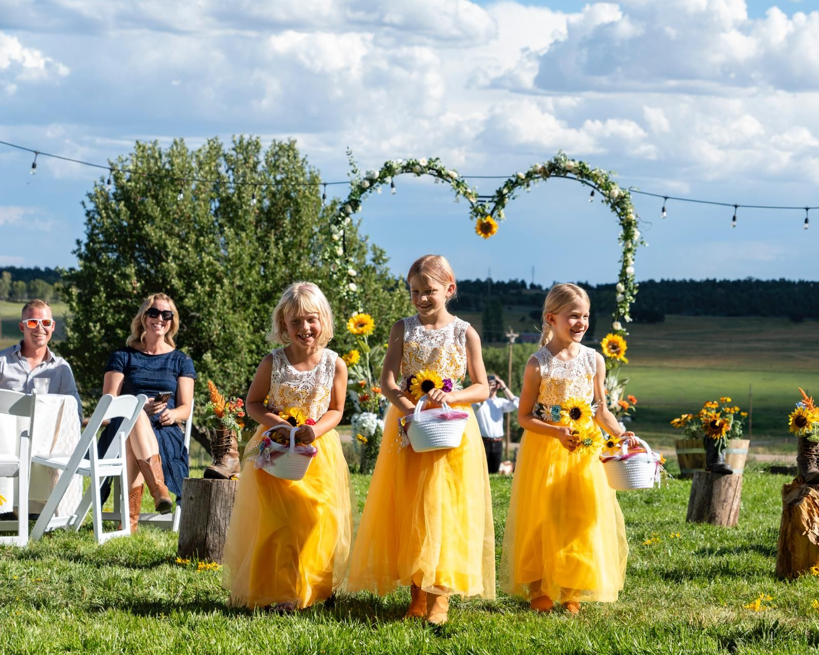 Flower girls walking down the aisle during an outdoor wedding ceremony at Three Willows Ranch Colorado