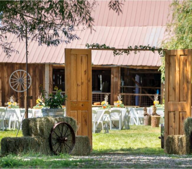Rustic wedding entrance with wooden doors and barn reception setup at Three Willows Ranch Colorado