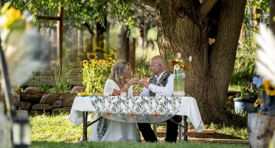 Couple enjoying a romantic outdoor dinner under a tree at Three Willows Ranch rustic wedding venue Colorado