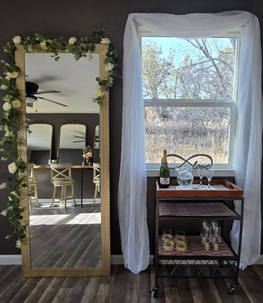 Bridal suite preparation area at Three Willows Ranch with mirror, vanity seating, and window decor